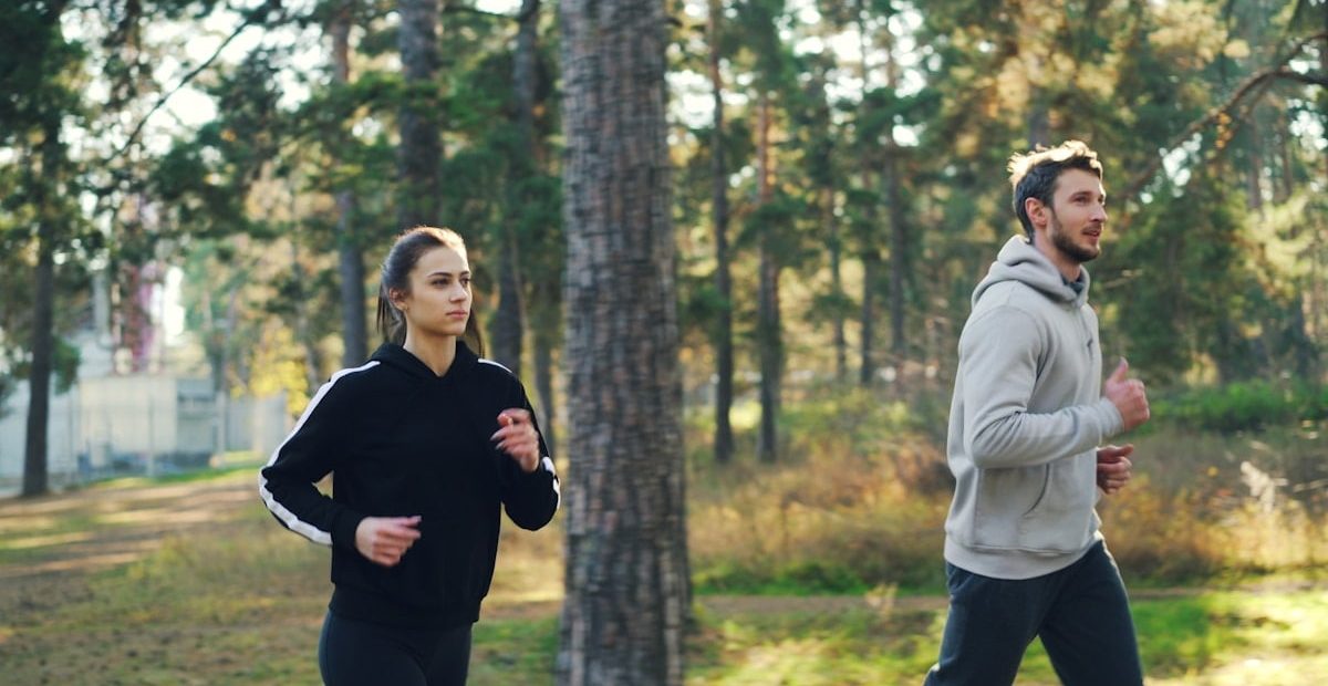 Man and woman jogging together in a park.
